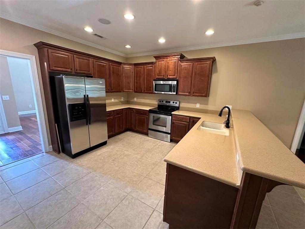 107 Savoy Place Calhoun, GA 30701 - Photo 12 of 32 a kitchen with stainless steel appliances a sink stove and cabinets