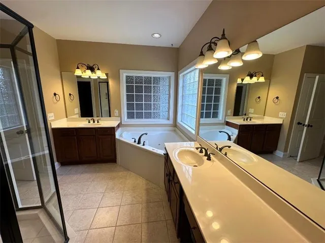 a bathroom with a tub sink and mirror