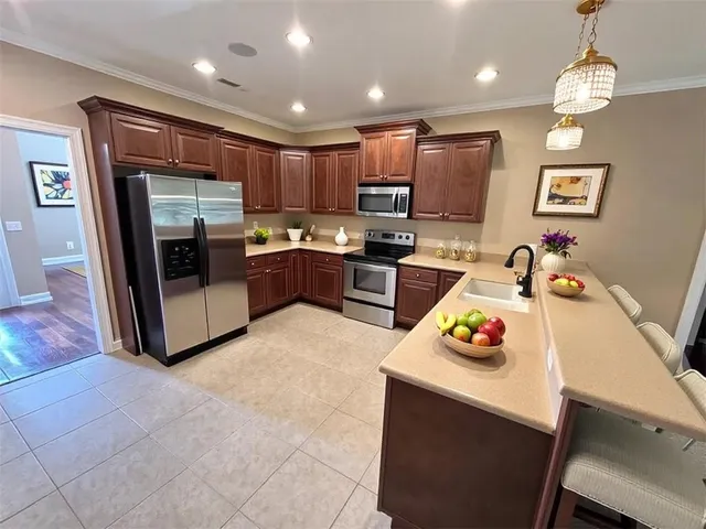 a kitchen with kitchen island granite countertop a sink appliances and cabinets