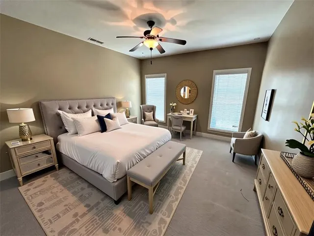 a spacious bedroom with a bed a couch and a chandelier