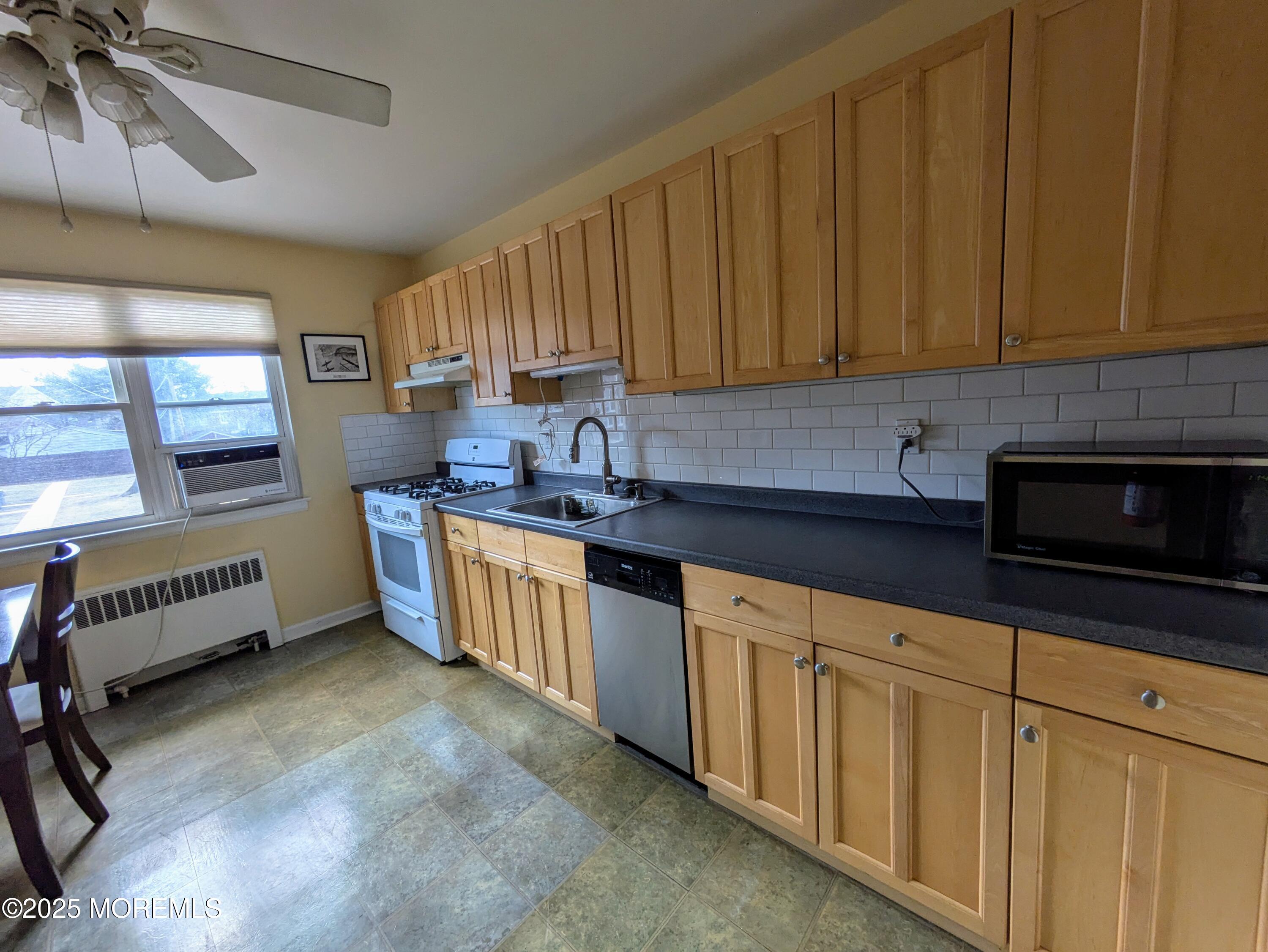 142 South Street, Unit 9A Red Bank, NJ 07701 - Photo 2 of 10 a kitchen with stainless steel appliances granite countertop a stove a sink dishwasher and a microwave oven with cabinets