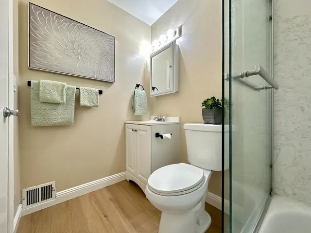 a bathroom with a toilet a sink and mirror