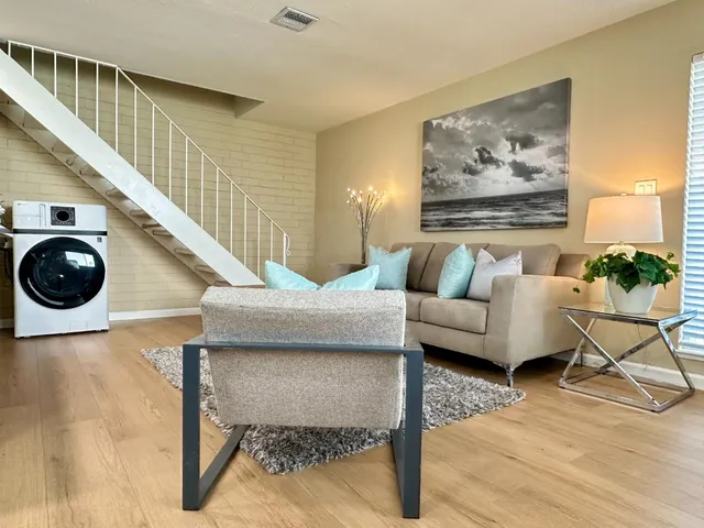 a living room with furniture and a wooden floor
