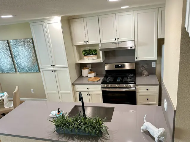 a kitchen with stainless steel appliances granite countertop a stove a microwave and a refrigerator