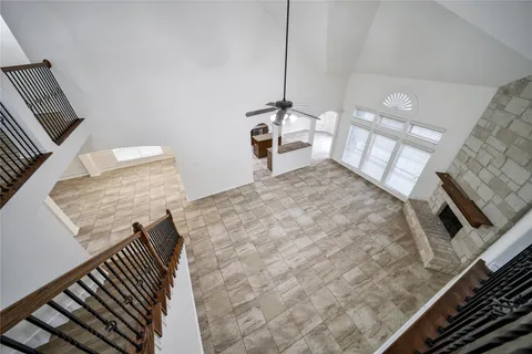 an empty room with wooden floor ceiling fan and windows