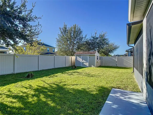 a view of a backyard with barn and a large tree
