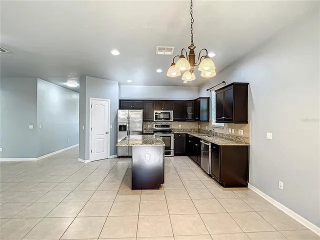 a view of kitchen with stainless steel appliances kitchen island a sink and a refrigerator