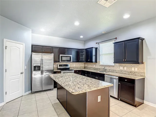 a kitchen with granite countertop stainless steel appliances and wooden cabinets