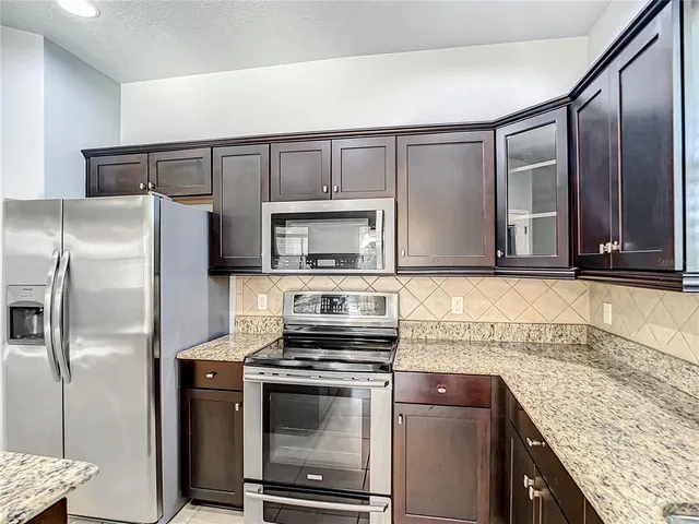 a kitchen with stainless steel appliances granite countertop a sink counter space cabinets and stainless steel appliances