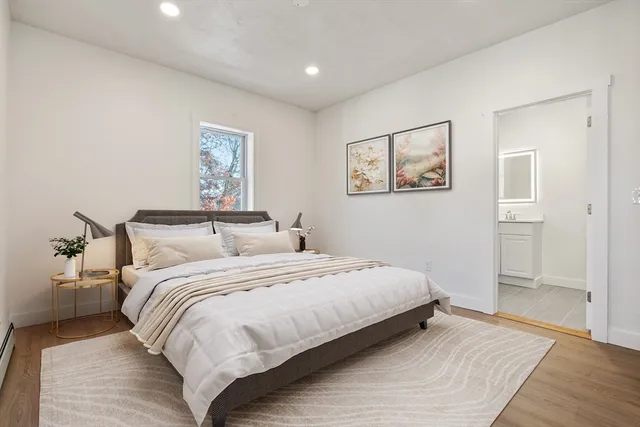 a bedroom with bed and a painting on the wall