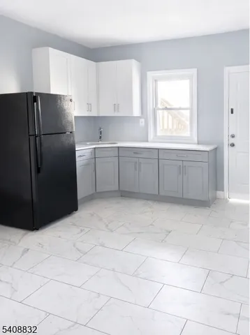 a kitchen with a refrigerator a stove top oven and cabinets