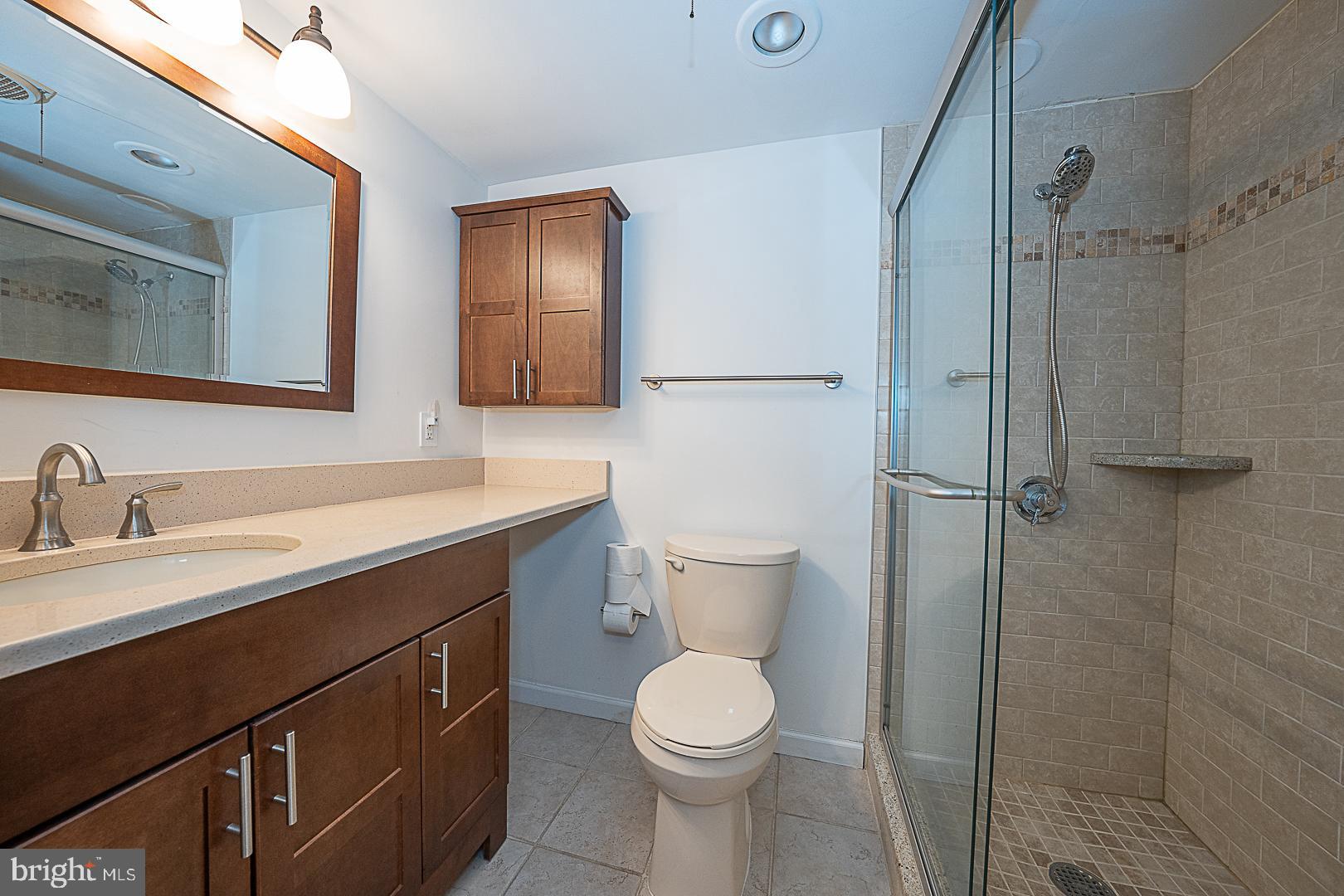 1919 Chestnut Street, Unit 1722 Philadelphia, PA 19103 - Photo 12 of 26 a bathroom with a toilet sink a shower and mirror