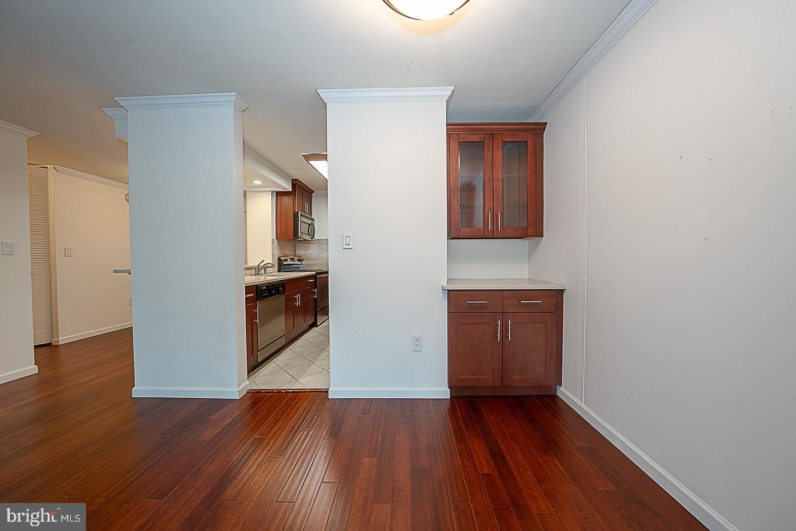1919 Chestnut Street, Unit 1722 Philadelphia, PA 19103 - Photo 4 of 26 a view of a hallway with wooden floor and a kitchen
