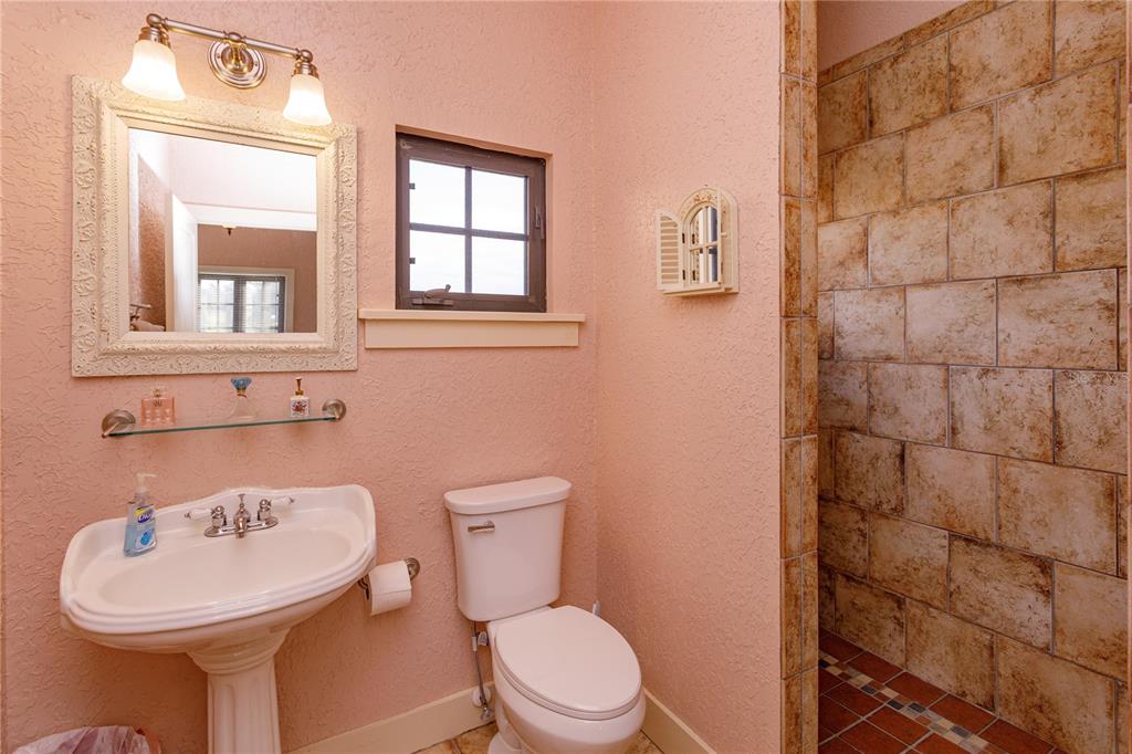 24540 Turkey Lake Road Howey-in-the-Hills, FL 34737 - Photo 31 of 42 a bathroom with a sink a toilet and mirror