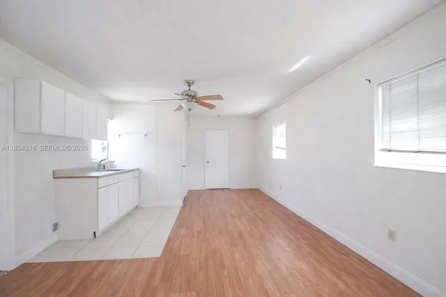 a backyard of a house with table and chairs plants and large trees