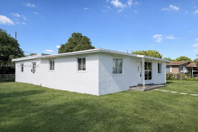 a front view of house with yard and trees in the background