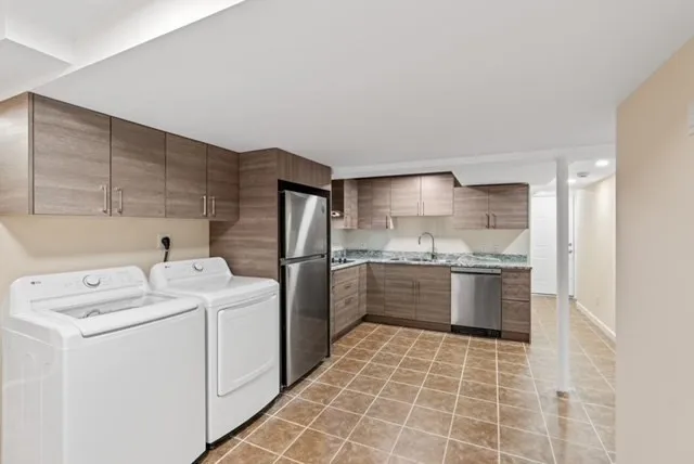 a large white kitchen with a sink a washer and dryer