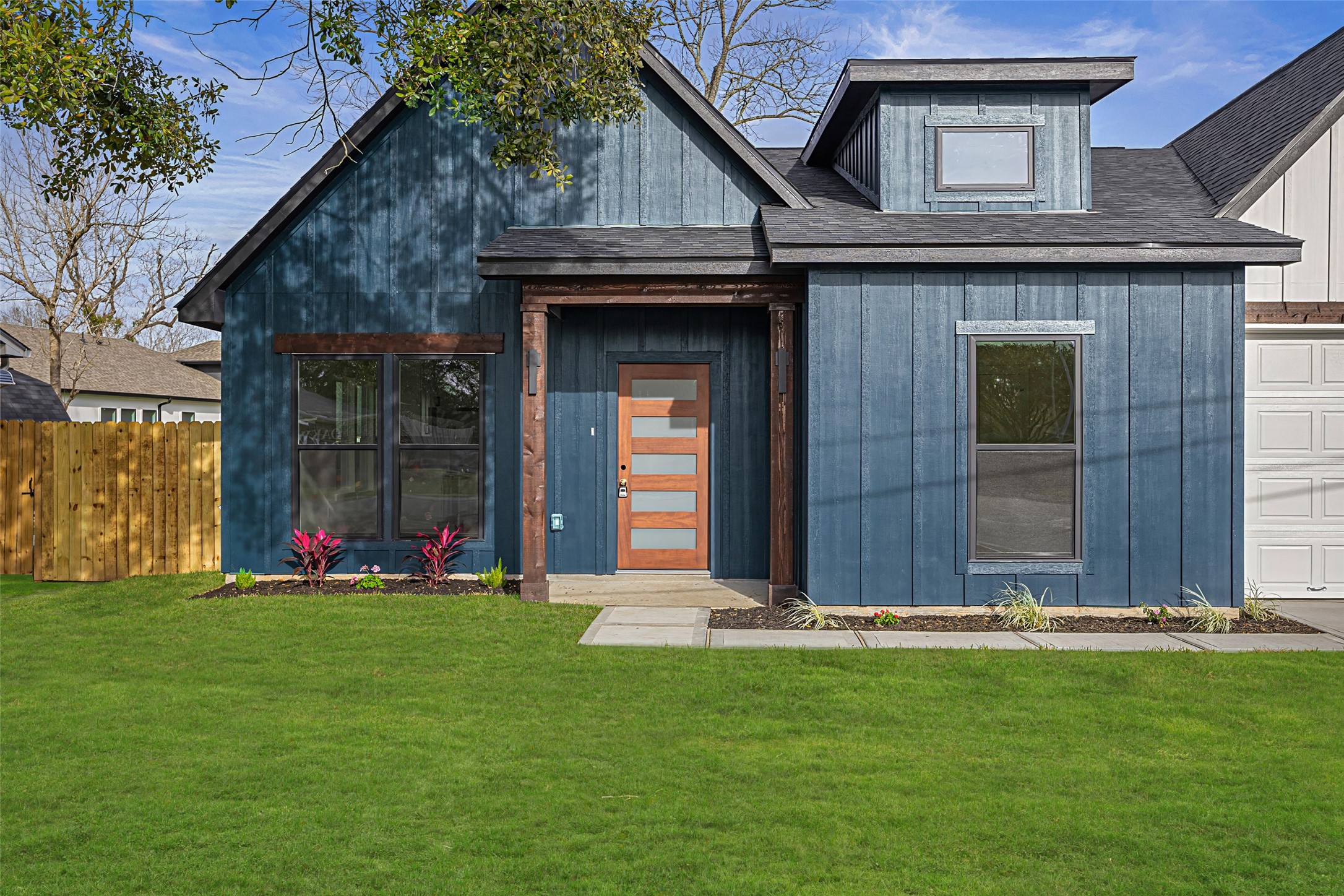 1807 Waco Street Dayton, TX 77535 - Photo 2 of 26 Inviting covered porch with modern wood and glass front door, statement beams, and stylish exterior finishes.
