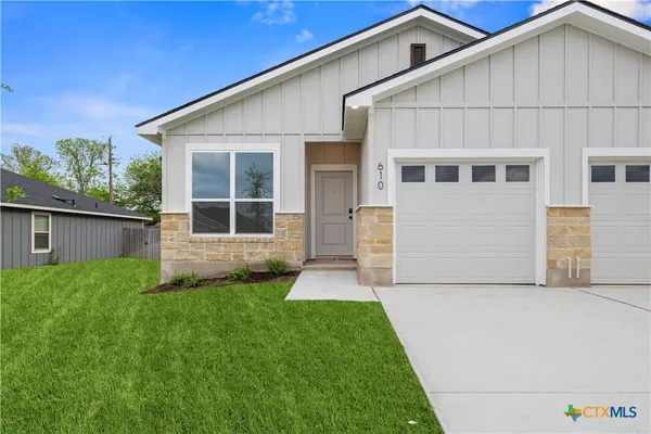 a front view of a house with a yard and garage