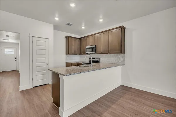 a kitchen with a refrigerator sink and cabinets