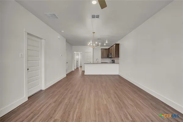 wooden floor in an empty room with a kitchen