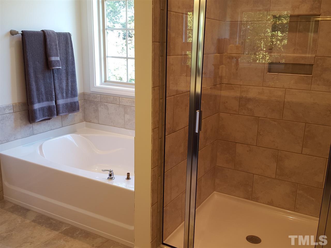 7524 Channery Way Raleigh, NC 27616 - Photo 13 of 25 a bathroom with a bathtub and a shower