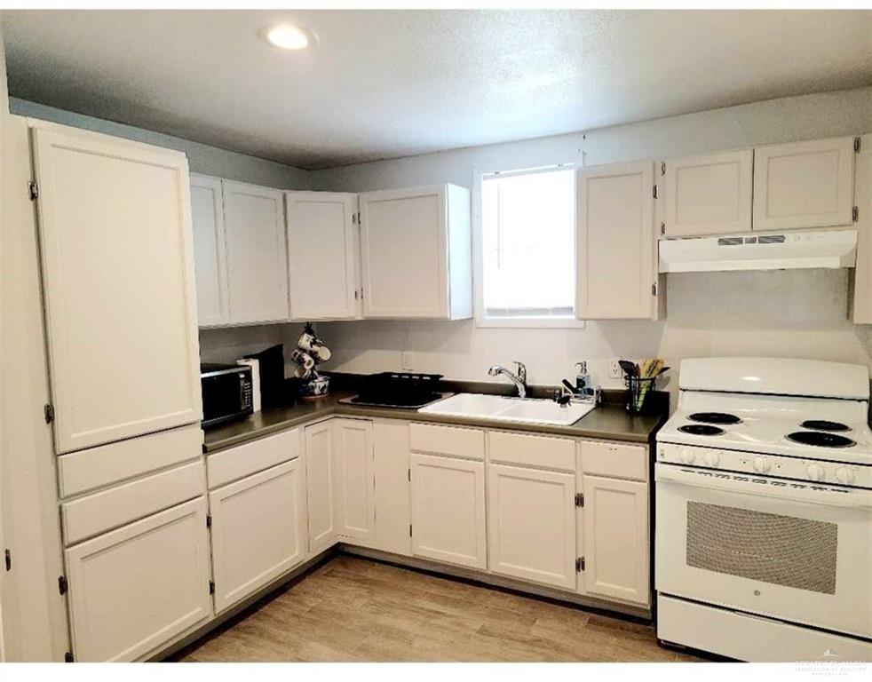 906 East Van Week Street Edinburg, TX 78541 - Photo 8 of 19 a kitchen with white cabinets and white appliances