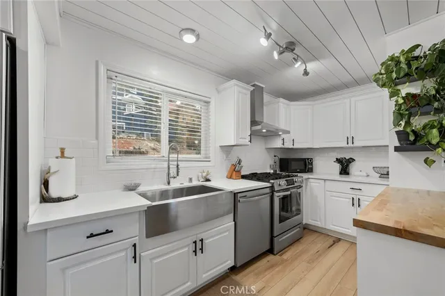 a kitchen with a sink stove top oven and cabinets