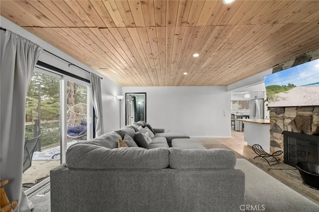 a living room with furniture a flat screen tv and a large window