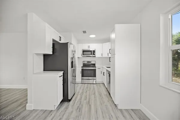 a kitchen with stainless steel appliances a refrigerator and a stove top oven