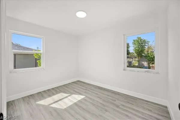 an empty room with wooden floor and window
