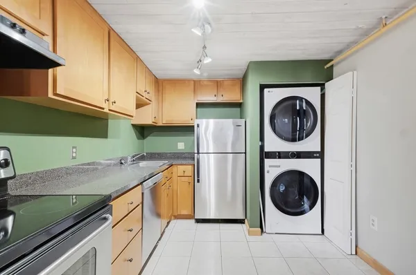 a living room with stainless steel appliances wooden floor and a window
