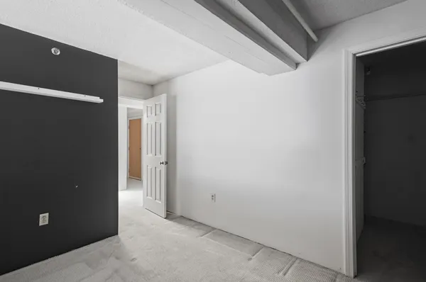 a view of an empty room with windows & cabinet