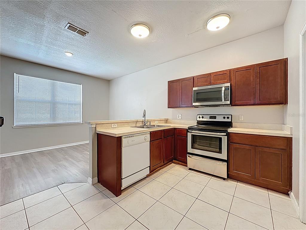1893 Royal Ridge Drive Davenport, FL 33896 - Photo 14 of 38 a kitchen with stainless steel appliances granite countertop a stove and a microwave