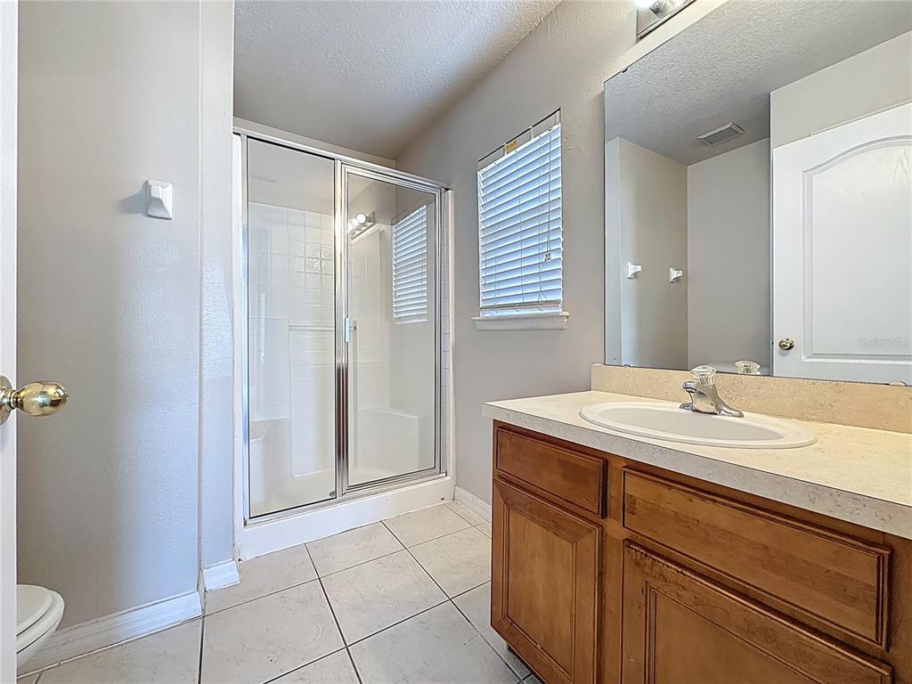 1893 Royal Ridge Drive Davenport, FL 33896 - Photo 26 of 38 a bathroom with a granite countertop sink and a mirror