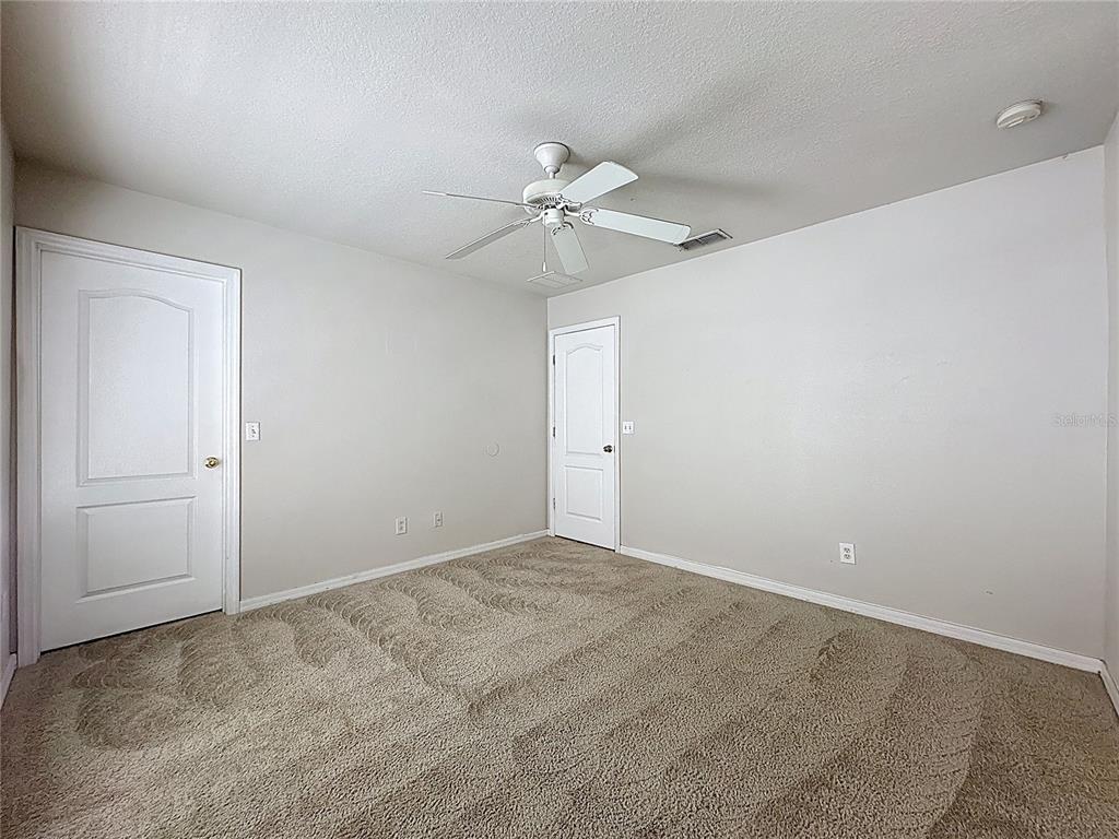 1893 Royal Ridge Drive Davenport, FL 33896 - Photo 37 of 38 an empty room with a chandelier fan and windows