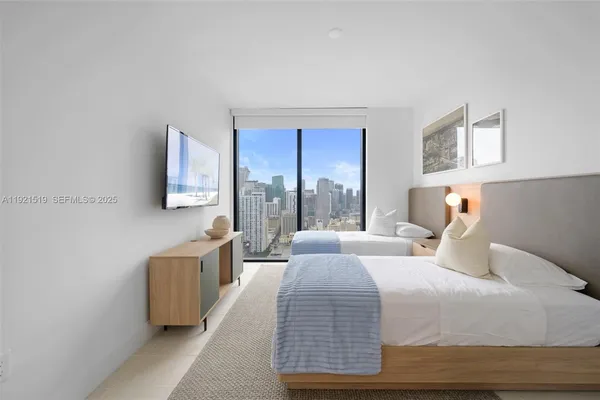 a bedroom with two beds and painting on the wall