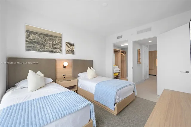 a bedroom with two beds and painting on the wall