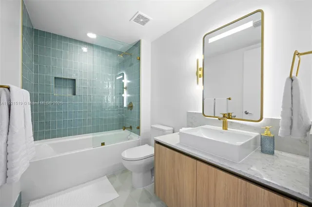 a bathroom with a granite countertop sink a toilet and bathtub