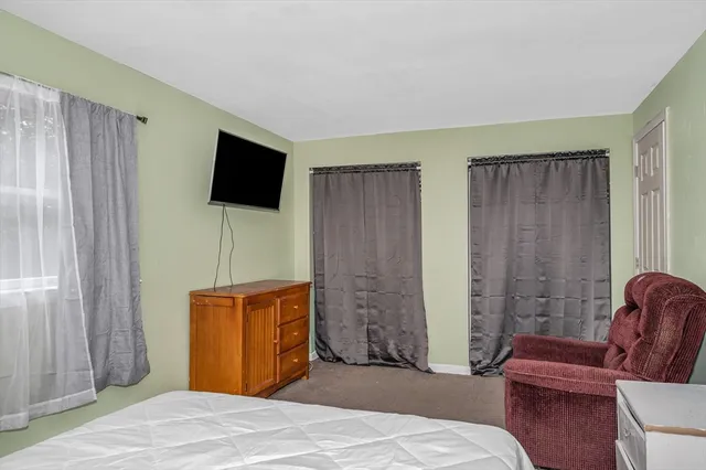 a bedroom with furniture and a flat screen tv