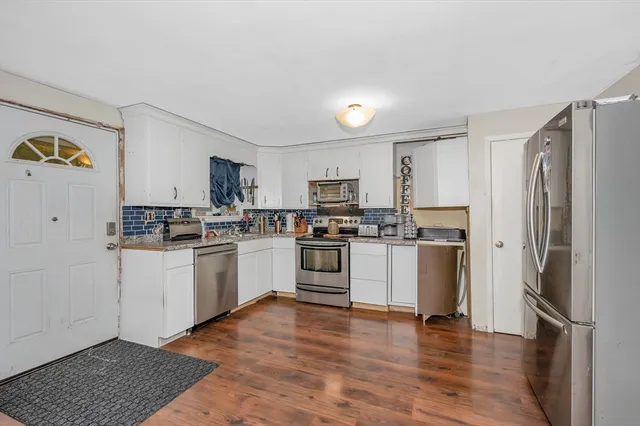 a kitchen with white cabinets and stainless steel appliances