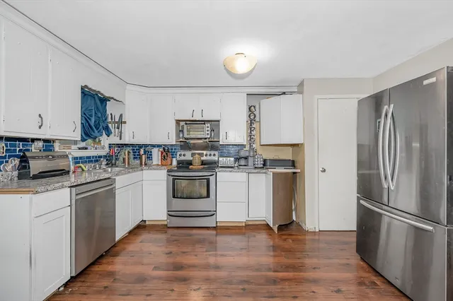 a kitchen with white cabinets and stainless steel appliances