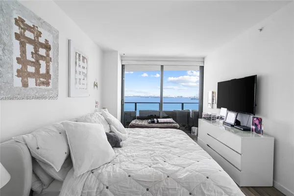 a bedroom with a bed and a flat screen tv