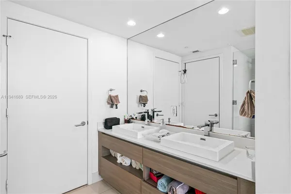 a bathroom with double vanity sink and a mirror