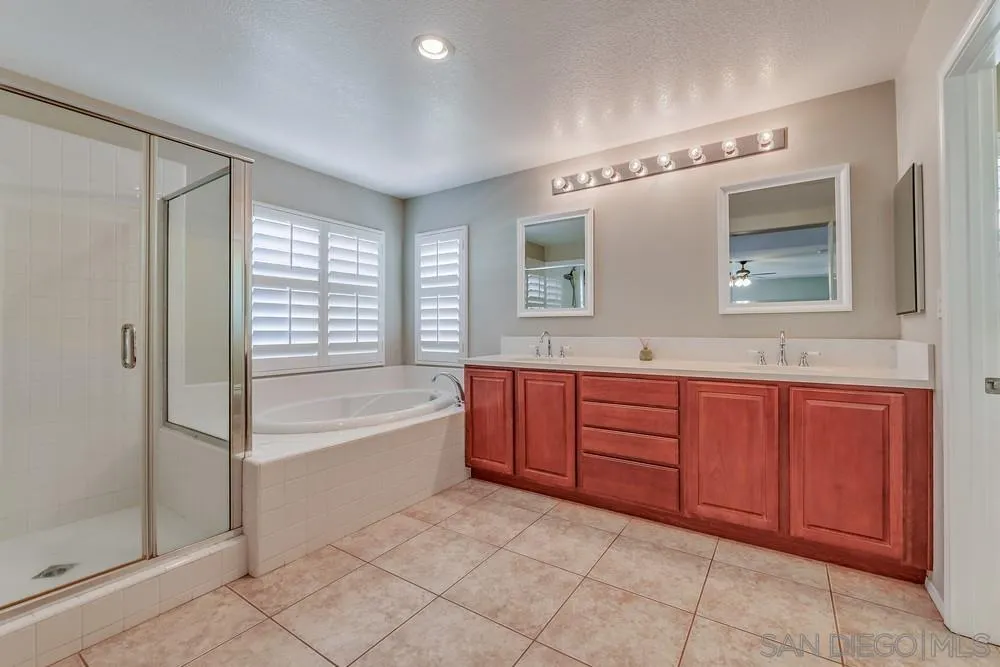 32758 Stonefield Lane Temecula, CA 92592 - Photo 16 of 30 a spacious bathroom with a granite countertop sink mirror and bathtub