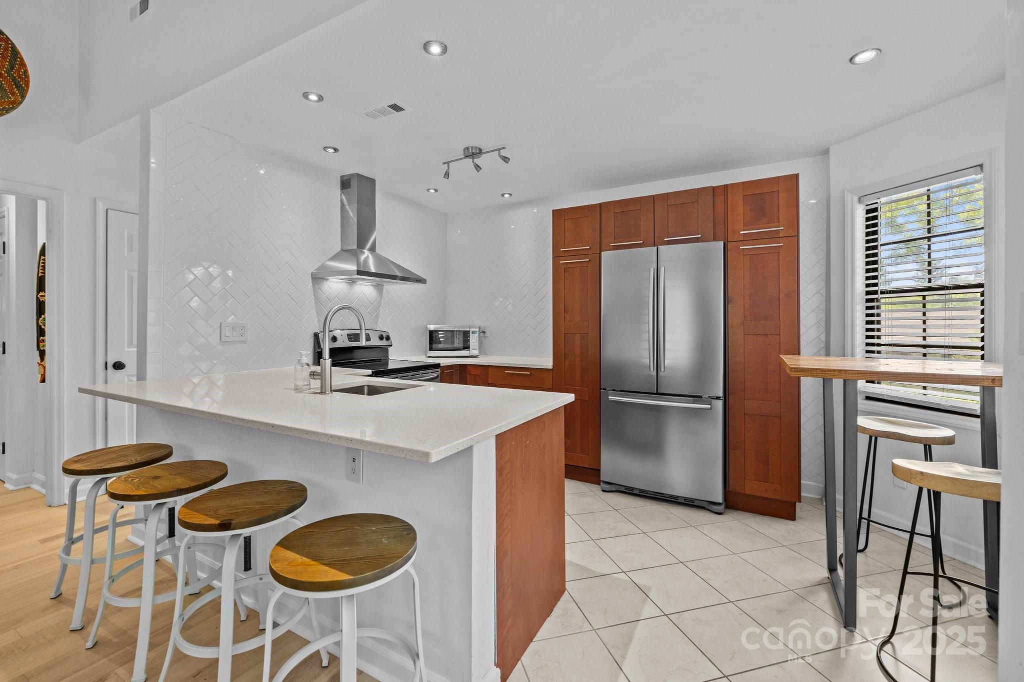a kitchen with stainless steel appliances granite countertop a sink a stove and a refrigerator