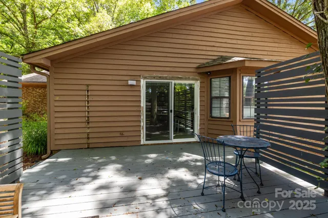 a view of a patio with table and chairs and wooden fence