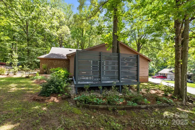 a view of a wooden house with a yard and plants