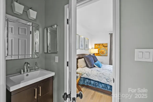 a en suite bathroom with a granite countertop sink and a mirror