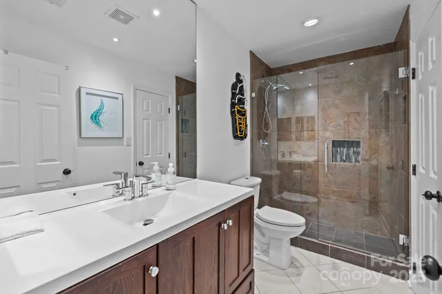a bathroom with a double vanity sink toilet and shower